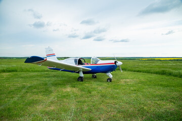 Fototapeta na wymiar Walking small propeller plane on a green field