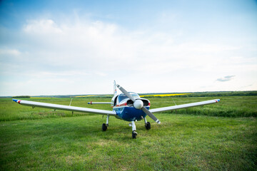 Walking small propeller plane on a green field
