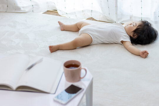ノートと電卓と、寝ている赤ちゃん（0歳、生後10か月、日本人、女の子）