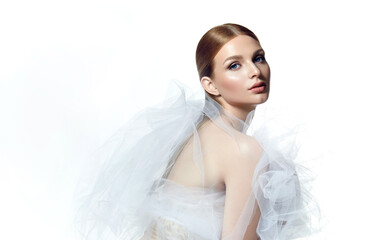 Portrait of a beautiful young woman with smooth fair skin. The head of a woman in an airy white shawl. Flying white, transparent fabric.