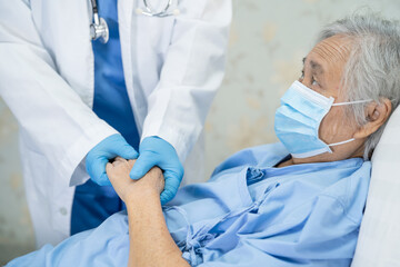 Doctor checking Asian senior or elderly old lady woman patient wearing a face mask in hospital for protect infection Covid 19 Coronavirus