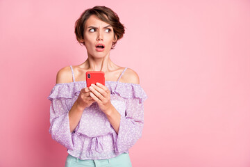 Photo of young shocked amazed surprised girl using smartphone look copyspace isolated on pink color background