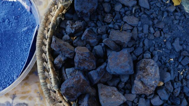 Moroccan blue, pure indigo rocks and indigo powder, natural dye stones pigments. Dark blue abstract background footage.