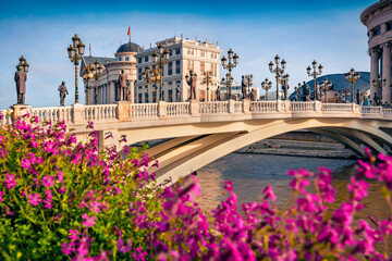 Blooming violet flowers on the shore of Vardar river. Splendid spring cityscape of capital of North...