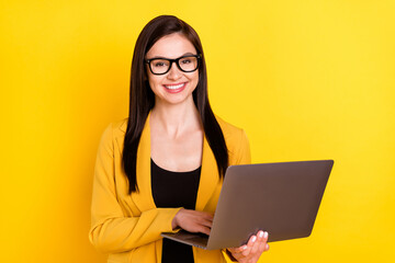 Photo of young business woman happy positive smile chat type email laptop isolated over yellow color background