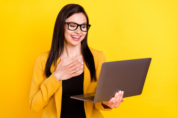 Photo of cute impressed woman wear formal jacket spectacles reading modern gadget smiling isolated yellow color background