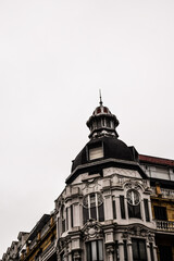 Fototapeta na wymiar Cúpula de un edificio con tonos negros y neutros con cielo nublado