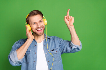Photo portrait of young guy listening music wearing headphones dancing enjoying isolated vibrant...