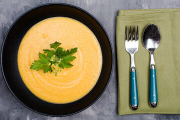 carrot puree soup in a black bowl