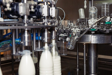 filling milk in to plastic bottles at the factory. equipment at the dairy plant