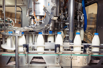 filling milk in to plastic bottles at the factory. equipment at the dairy plant