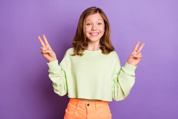 Photo of young excited girl happy positive smile show peace cool v-sign greetings isolated over violet color background © deagreez
