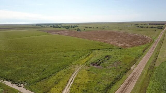 Aerial Descending Shot Of Pathway Amidst Green Landscape Against Sky - Oakley, Kansas