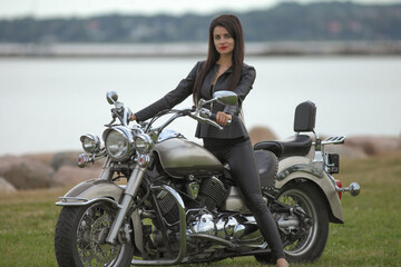 Fototapeta na wymiar Portrait of young woman in black on motorcycle