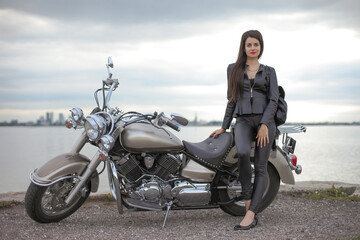 Fototapeta na wymiar Portrait of young woman in black on motorcycle