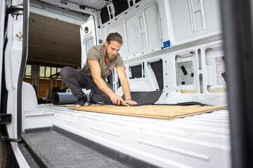 Man cutting foam insulation inside a van