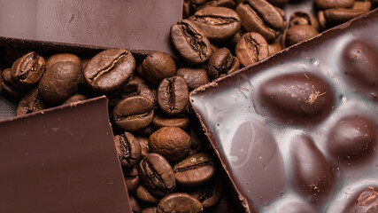 coffee beans close-up and chocolate. Dark chocolate bar. Natural background of cinnamon color.