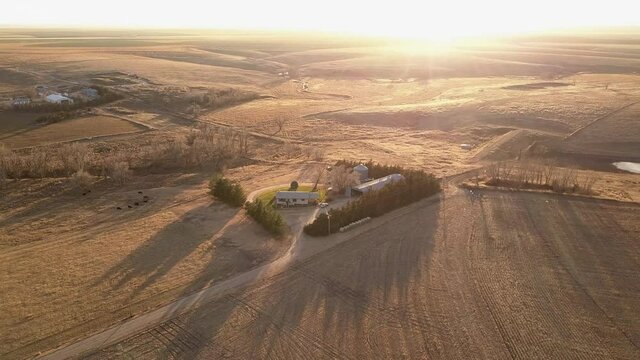 Aerial Backward Shot Of Houses And Garage In Filed On Sunny Day, Drone Flying Over Harvested Landscape During Sunny Day - Oakley, Kansas