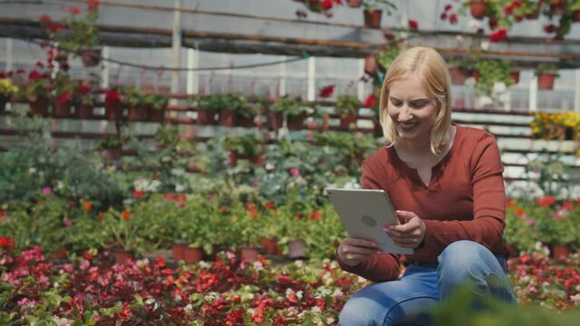 Smiling woman using digital tablet in greenhouse