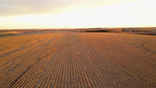 Aerial Forward Shot Of Harvested Crops During Sunset Against Cloudy Sky - Oakley, Kansas