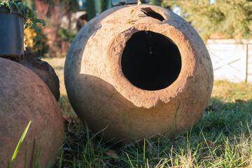 Georgian traditional ancient jug for wine qvevri on the ground lit by sunlight