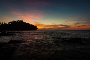 Obraz premium Vivid sunset sky waterscape and silhouette forest island