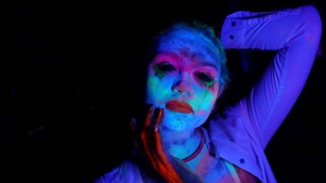 lady with fluorescent makeup, medium portrait in UV lights in darkness