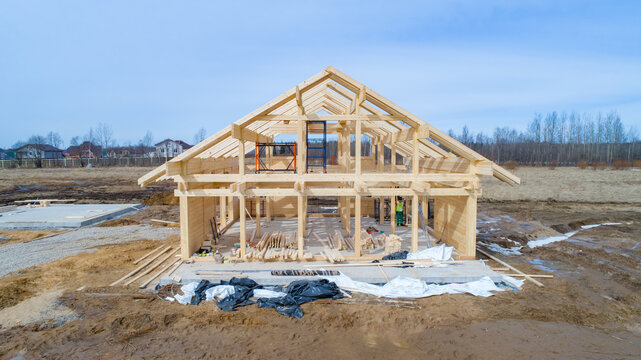 Country building. Building a house from wood. Wooden frame on a blue sky background. Frame house is being built on a vacant lot. Frame of a one-story house. Country building services.