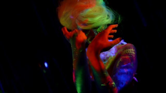gorgeous fluorescent makeup on young woman, figure in UV lights, magic and mystery