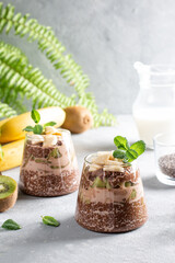 Vegan dessert, chia pudding with kiwi and banana on gray table. Superfood.