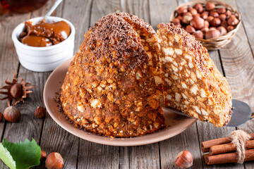 Traditional Russian cake Anthill decorated with chocolate on the wooden table