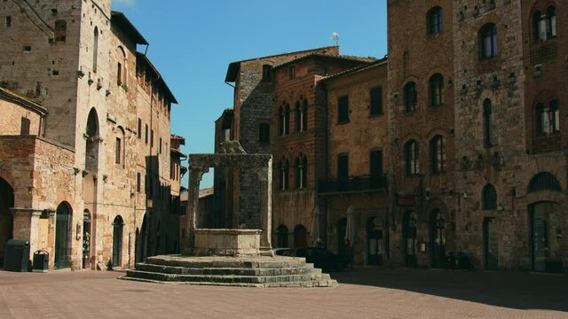 Fountain and old buildings on town square, San Gimignano, Tuscany, Italy