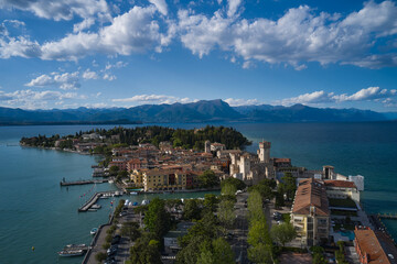 Sirmione, Lake Garda, Italy. Aerial view of the island of Sirmione. Castle on the water in Italy. Peninsula on a mountain lake in the background of the alps. Panorama of Lake Garda.