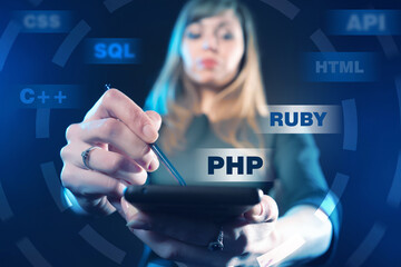 Programming Web site development. Girl chooses a programming language. Woman developer holds tablet in her hands. Web developer on a dark background. Website building. Website launch. PHP. SQL. RUBY