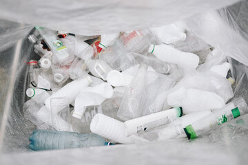 Sorting and collection plastic bottles in trash bag for recycling. Trash bag with PET 1 in the rain. Zero waste concept.