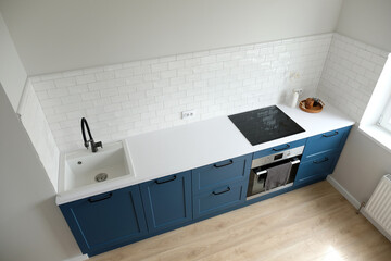 Scandinavian interior design. Small kitchen room with blue cabinets and white countertop, Nordic...