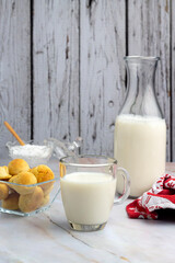 breakfast and snack with milk, chocolate and homemade breads with bottle and elegant glass and sugar on counter and wooden background