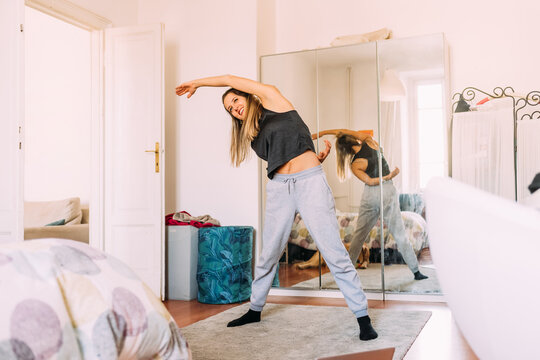 Young Woman Stretching At Home