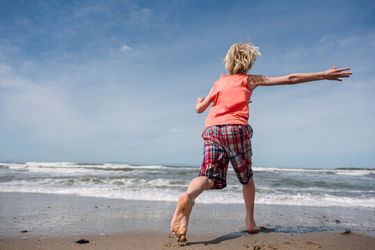 USA, California, Ventura, Rear view of boy running on beach