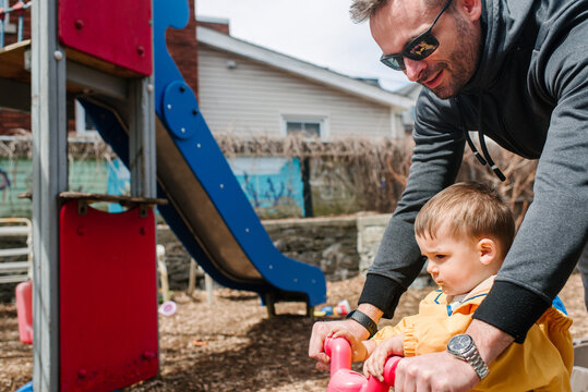 Canada, Kingston, Father with son riding small bike in playground