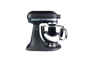 modern matte black standing mixer with stainless steel bowl is on the white table with white wall background of the kitchen