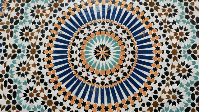 Colorful star-shaped pattern in traditional Islamic geometric design from a public fountain in Marrakech, Morocco. Made with natural colors from indigo, saffron, mint, kohl. Camera movement zooming in