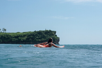 Young woman with beautiful body in swim suit surfer on surf board