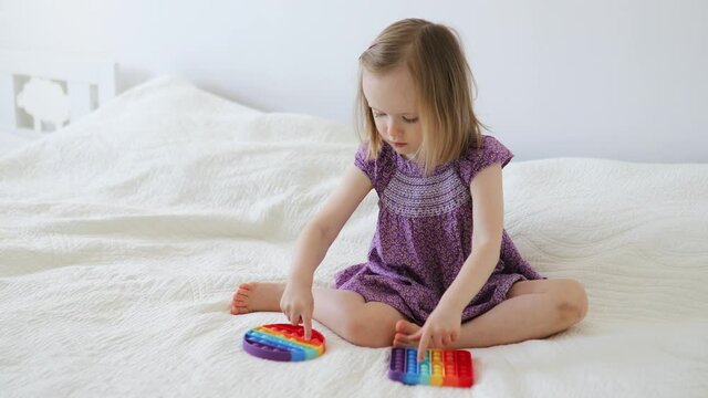 Adorable little girl playing with pop it fidget