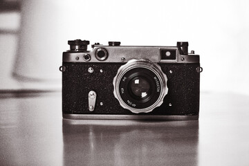 A Retro camera of classic design against a White Background. Black and White, stylized as old photo