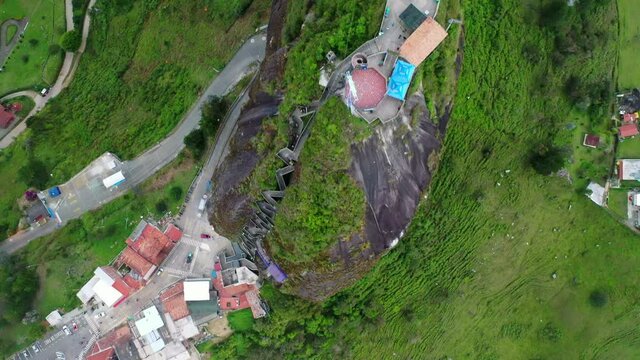 Aerial Top Forward Shot Of El Penon Rock Formation, Drone Flying Over Famous Landmark During Day - Guatape, Colombia