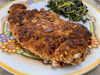 Cotoletta fatta con carne di maiale, uova e tarallo napoletano con contorno di friarielli napoletani