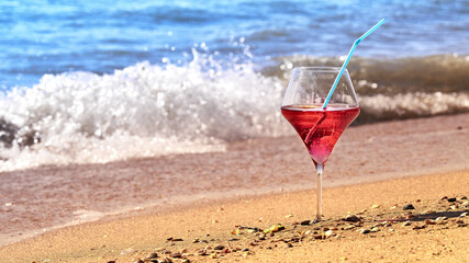 Wine glass with a cocktail by the sea.