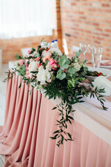 Floristic composition of fresh flowers decorates festive table. Rustic decoration of celebration. Selective focus.