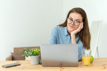 Student thinking while doing complicated homework on line with a laptop at home. Photo of young...